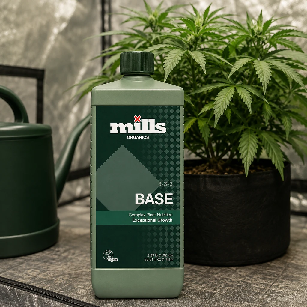 Botella verde de Mills Organics Base con etiqueta 3-3-3, delante de una planta en maceta y junto a una regadera en un armario de cultivo. Botella verde de Mills Organics Base con etiqueta 3-3-3, delante de una planta en maceta y junto a una regadera en un armario de cultivo.