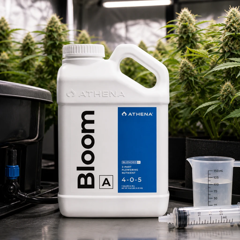 Garrafa blanca de Athena Bloom A con etiqueta azul, junto a un vaso graduado y una jeringa, con plantas en flor al fondo.