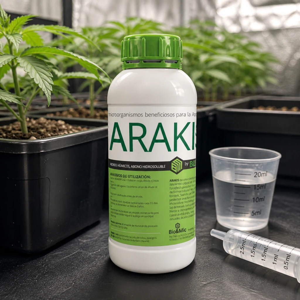 Bote de Arakis con tapón verde junto a un vaso graduado con líquido y una jeringa, con plantas en macetas al fondo.