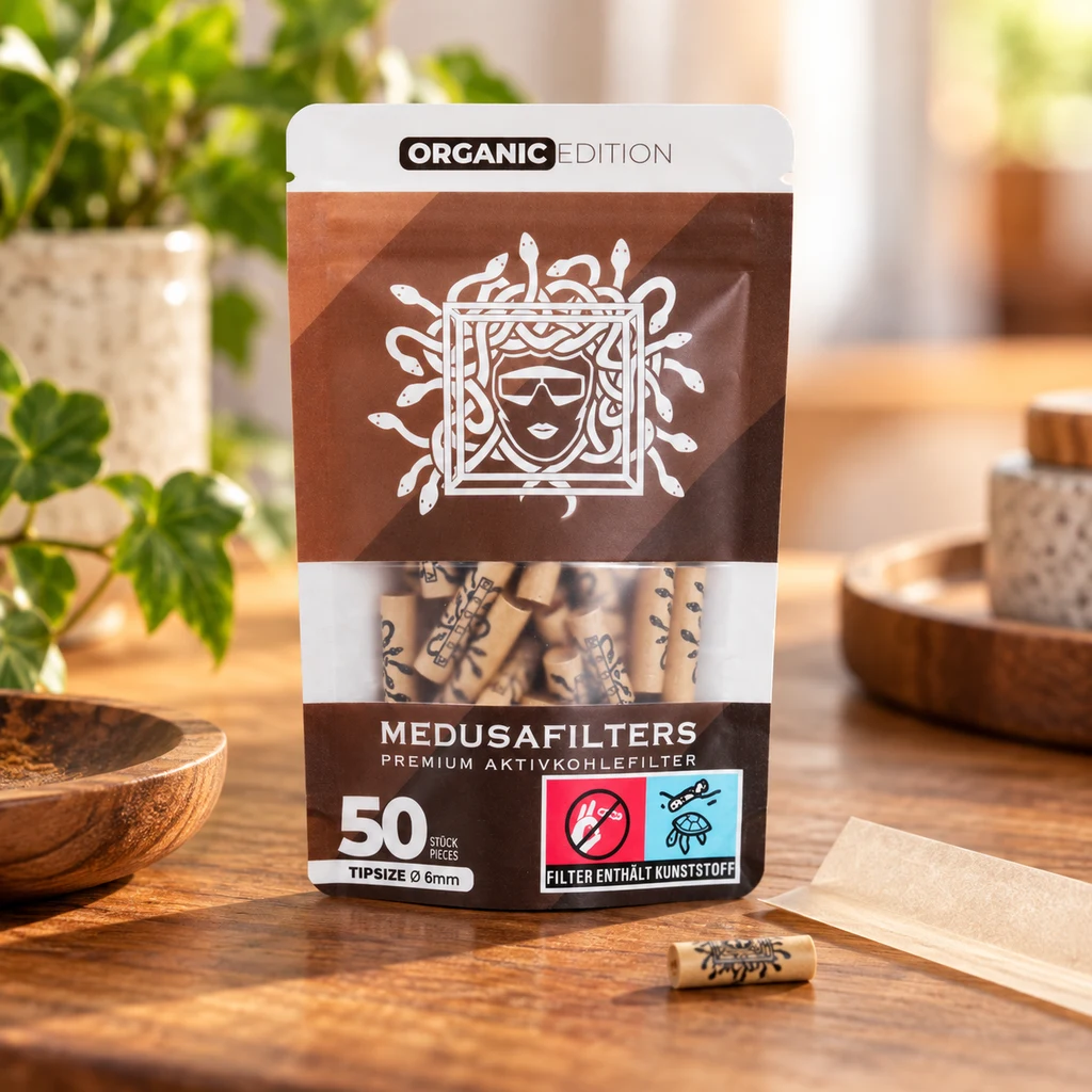 Bolsa Medusa Organic Edition con ventana que muestra filtros, sobre una mesa de madera junto a un filtro suelto y papel de liar.