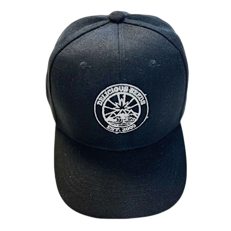 Gorra negra con visera curva y emblema circular blanco bordado en el frontal con el texto Delicious Seeds.
