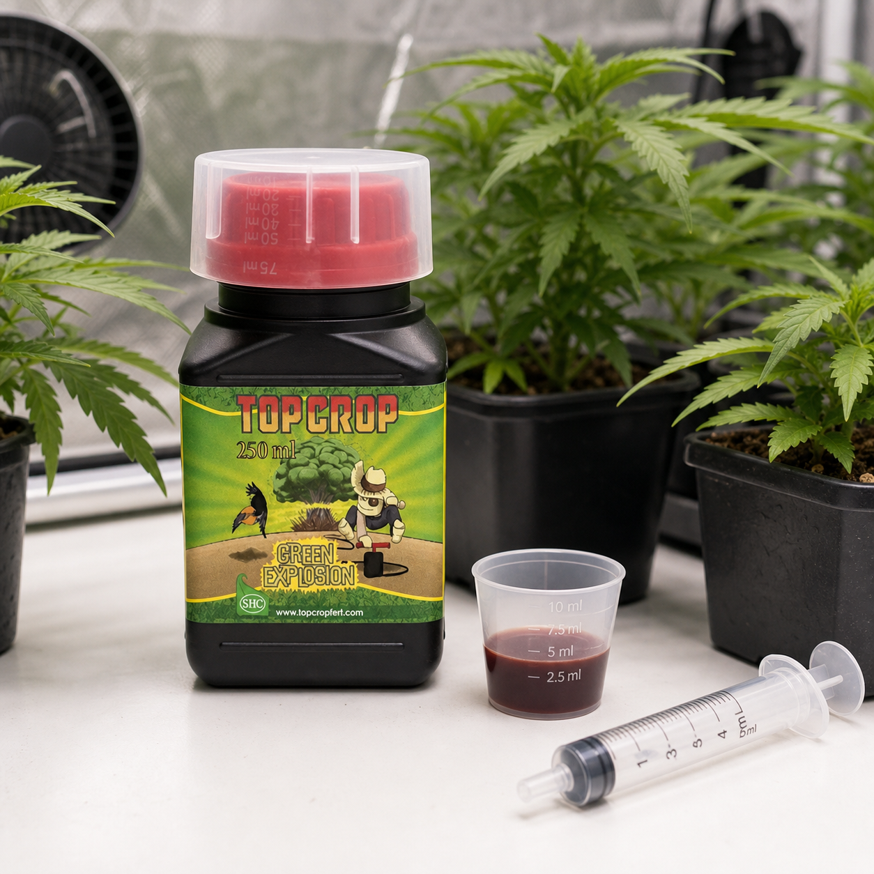 Bote de Green Explosion Top Crop de 250 ml junto a un vaso con líquido oscuro y una jeringa dosificadora, ante plantas en macetas. Bote de Green Explosion Top Crop de 250 ml junto a un vaso con líquido oscuro y una jeringa dosificadora, ante plantas en macetas.