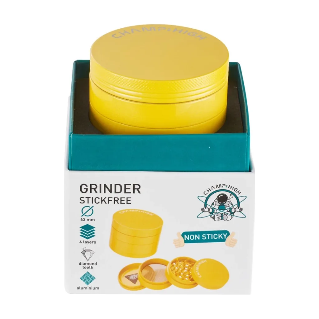 Grinder Champ High amarillo dentro de su caja abierta, con frontal que indica 63 mm, cuatro capas y dientes de diamante.
