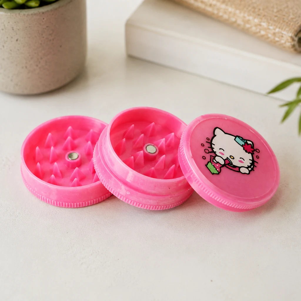 Molinillo rosa abierto, con dientes puntiagudos e imanes centrales visibles y tapa con dibujo de Hello Kitty, sobre una mesa clara.