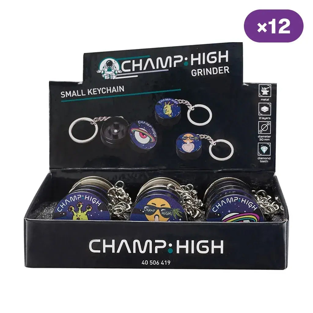 Expositor Champ High con grinders llavero de distintos diseños, uno abierto en la gráfica y distintivo ×12 en la esquina superior.