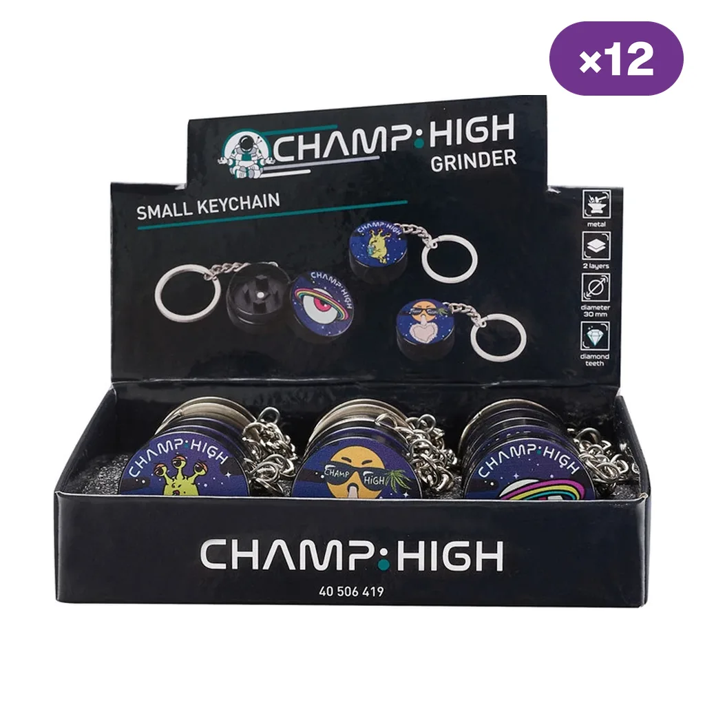Expositor Champ High con grinders llavero de distintos diseños, uno abierto en la gráfica y distintivo ×12 en la esquina superior.