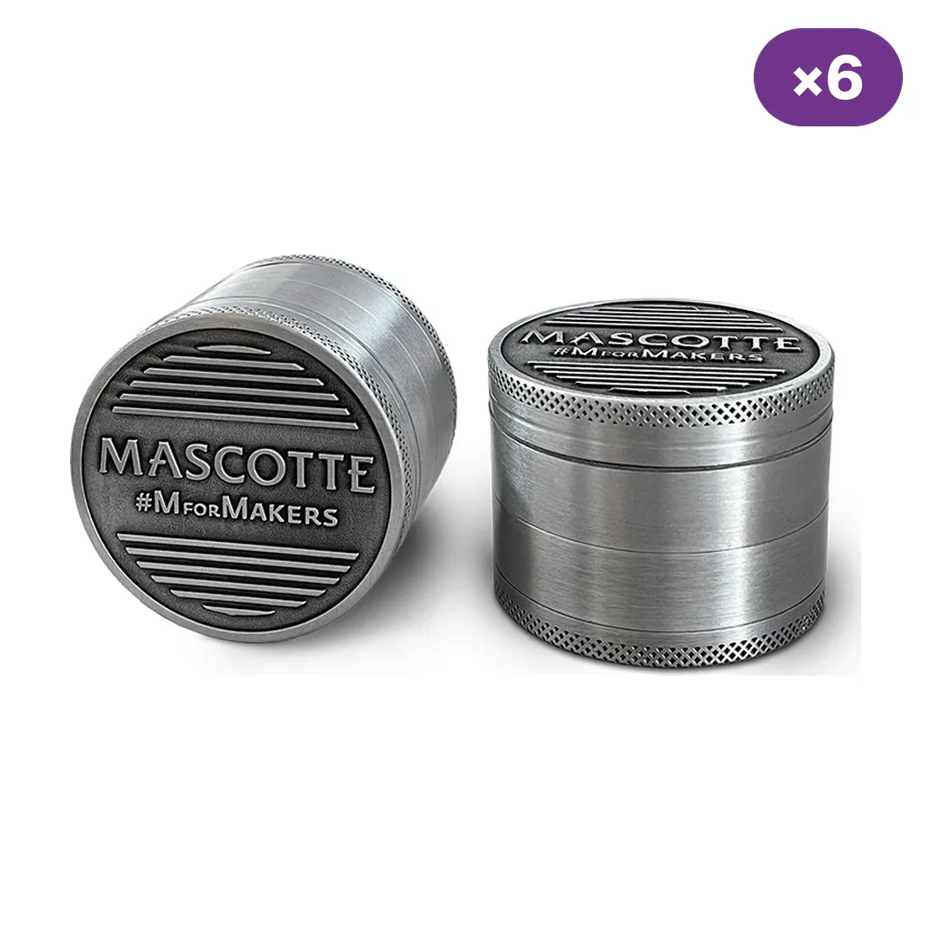Dos grinders Mascotte plateados, uno de pie y otro inclinado mostrando la tapa con el logotipo, junto a un distintivo «×6».