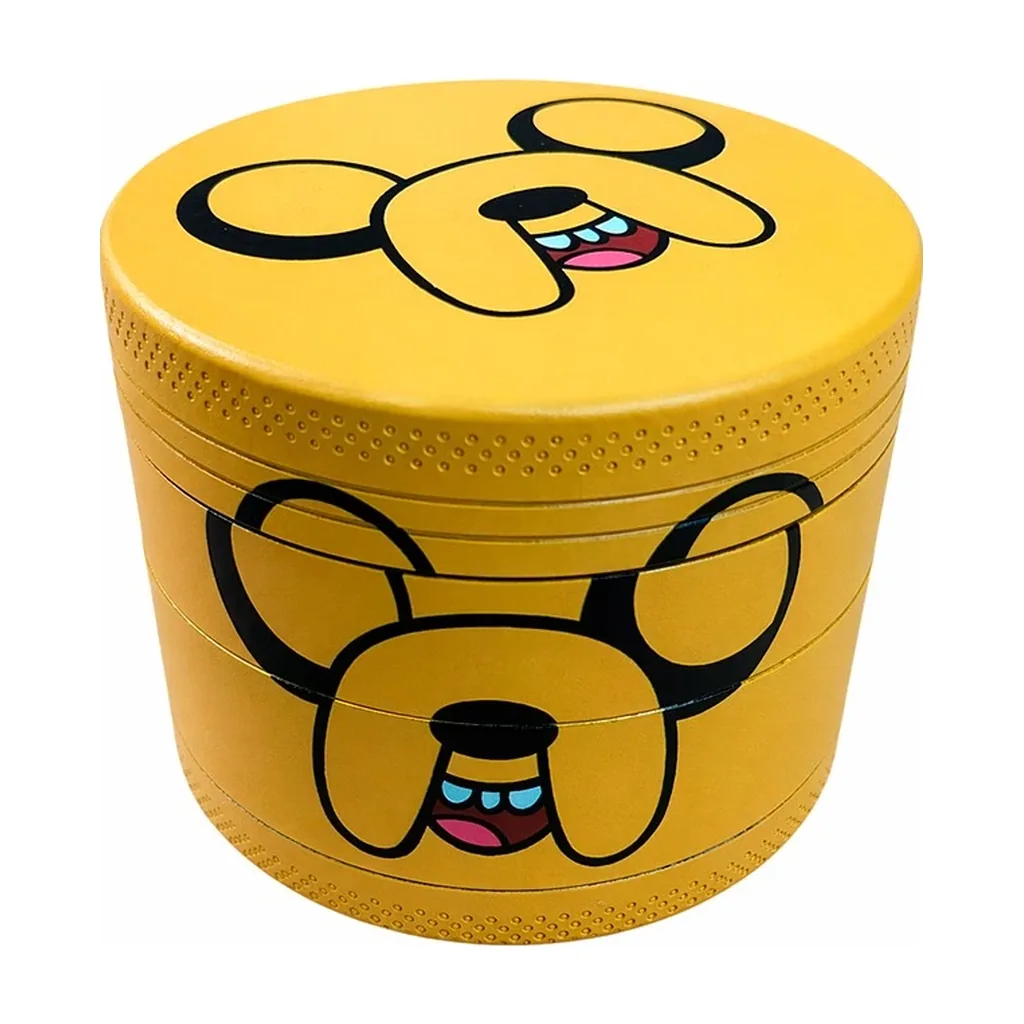 Grinder metálico amarillo Jake Dog, con el rostro del personaje en la tapa y el lateral, sobre fondo blanco.