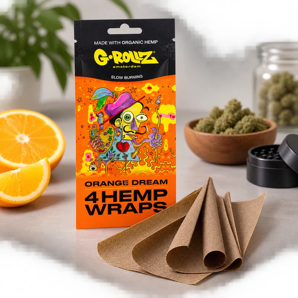 Envase naranja de G-Rollz Orange Dream con ilustración colorida, wraps marrones delante y naranja cortada, cogollos y grinder alrededor. Envase naranja de G-Rollz Orange Dream con ilustración colorida, wraps marrones delante y naranja cortada, cogollos y grinder alrededor.