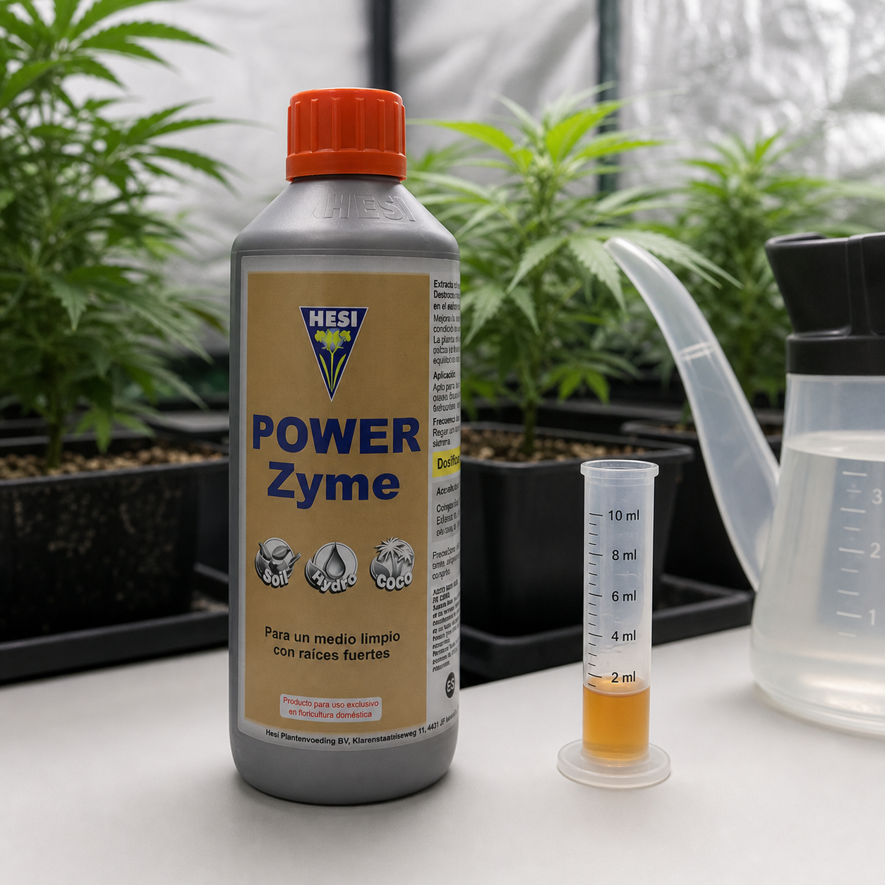 Botella de HESI Power Zyme con tapón naranja junto a una probeta con líquido ámbar y una regadera, con plantas en macetas al fondo.