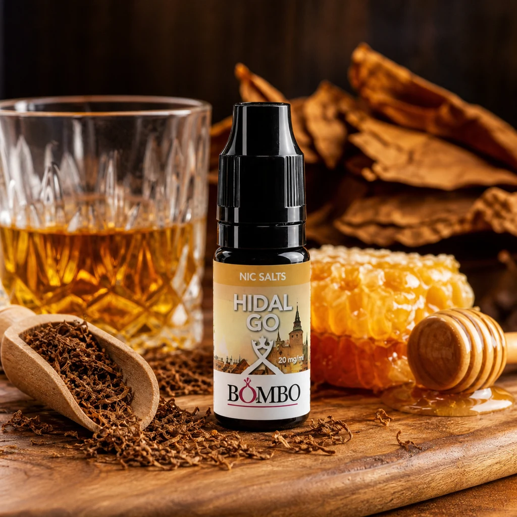 Bote Hidalgo Bombo Nic Salts con tapón negro, junto a un vaso con líquido ámbar, tabaco, un panal y un utensilio para miel sobre madera.