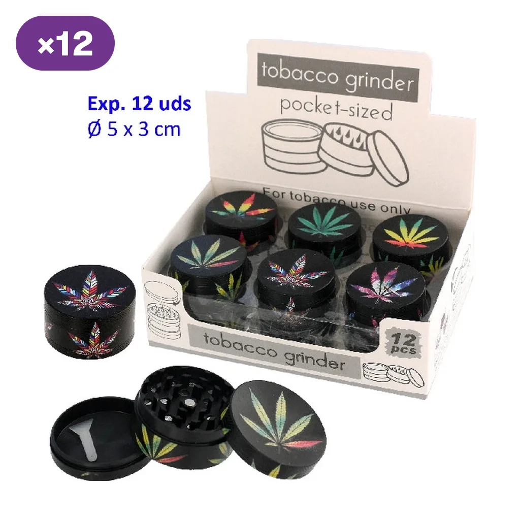 Grinders negros con hojas multicolores en un expositor; uno aparece desmontado, mostrando los dientes y una pequeña espátula.