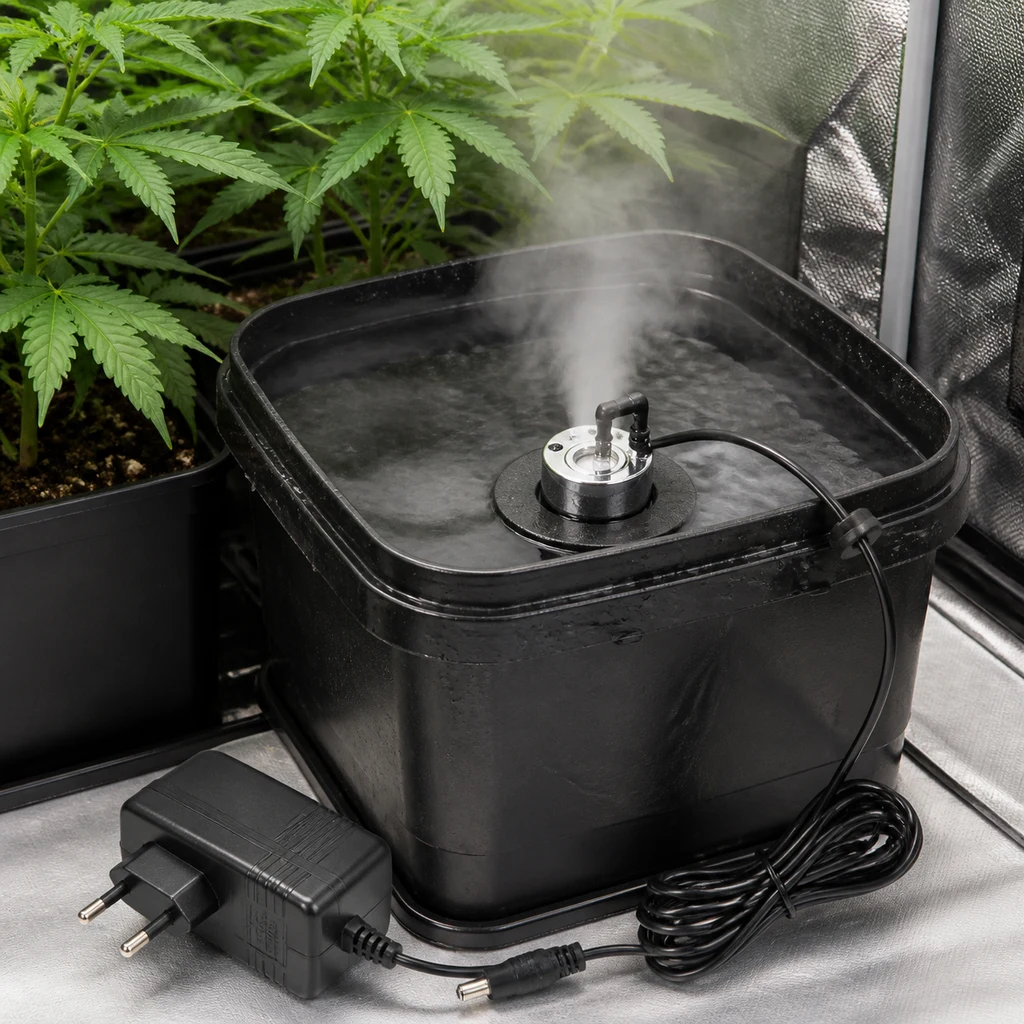 Humidificador ultrasónico sobre un flotador en un recipiente negro con agua y niebla, junto a plantas y un adaptador eléctrico.