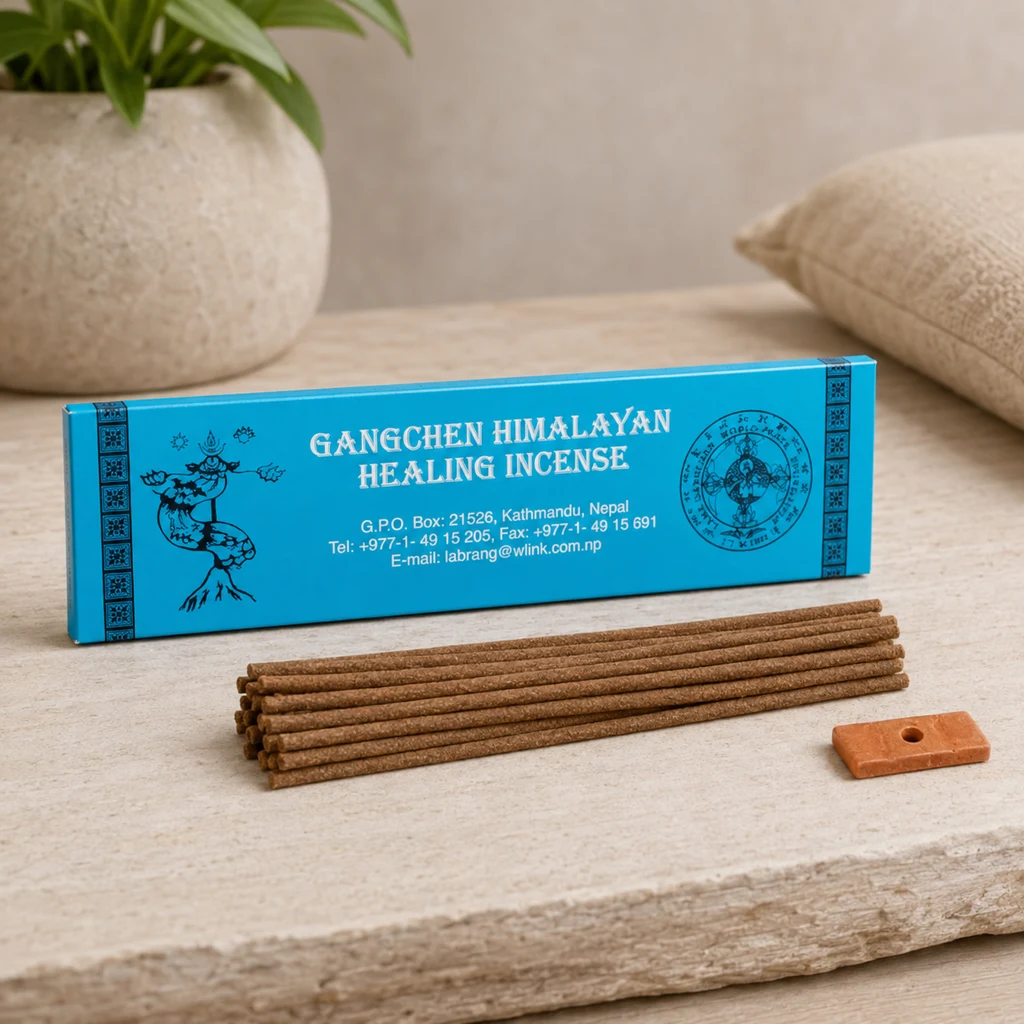 Caja azul de incienso Gangchen Himalayan Healing Incense con varias varillas marrones y un pequeño soporte sobre una mesa clara. Caja azul de incienso Gangchen Himalayan Healing Incense con varias varillas marrones y un pequeño soporte sobre una mesa clara.