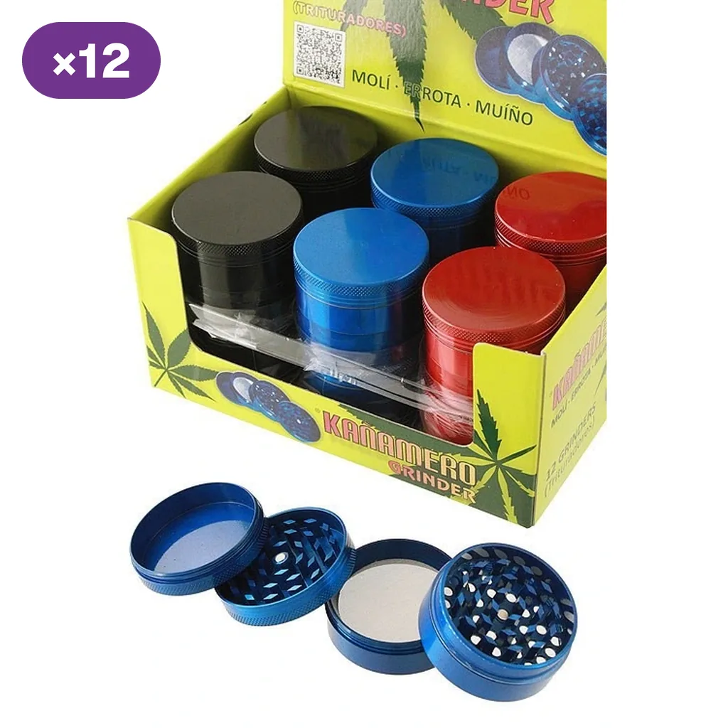 Expositor Kañamero con grinders negros, azules y rojos y distintivo «×12»; delante, un grinder azul desmontado en cuatro piezas.