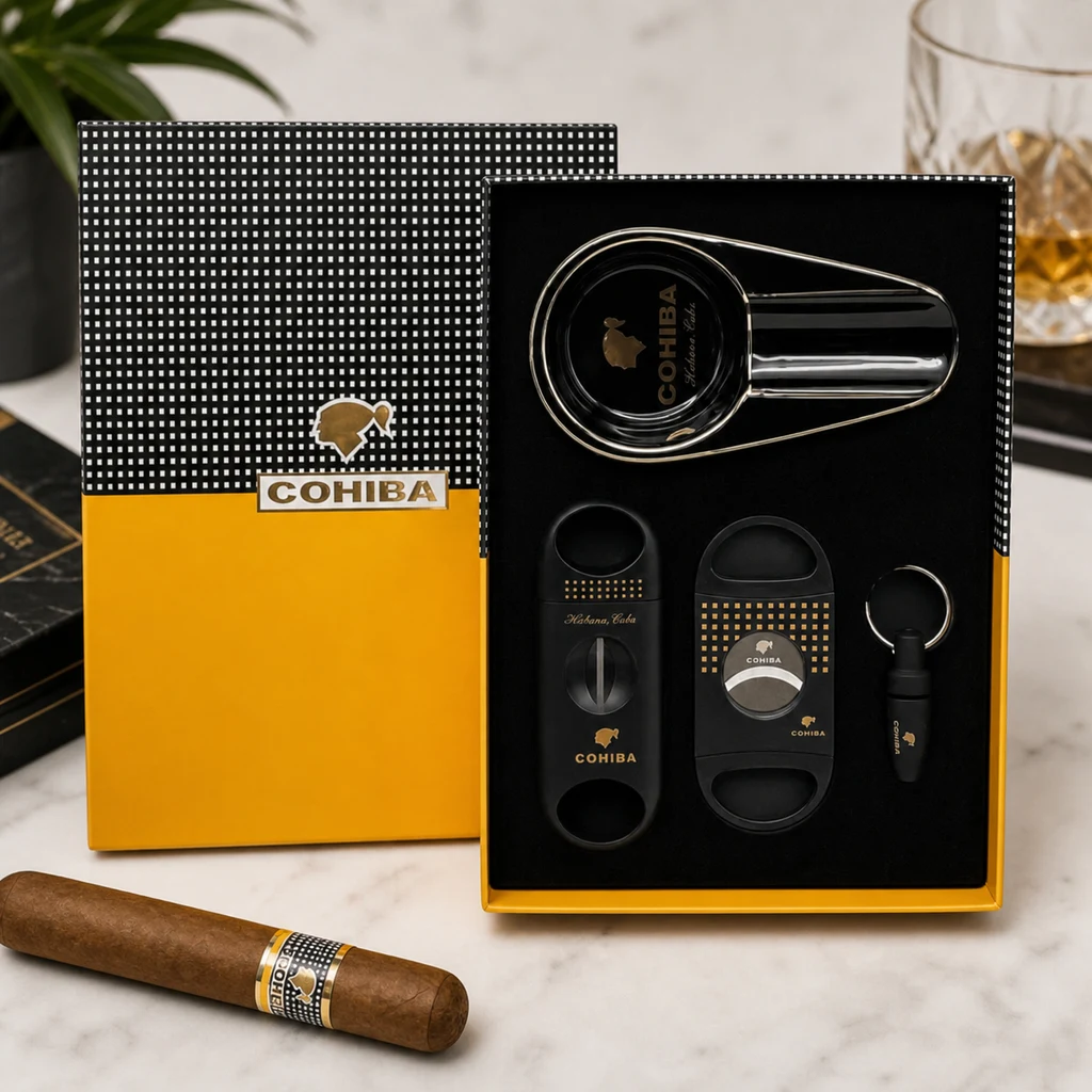 Set Cohiba en estuche negro y amarillo abierto, con cenicero, dos cortapuros y accesorio con anilla; un puro aparece delante.