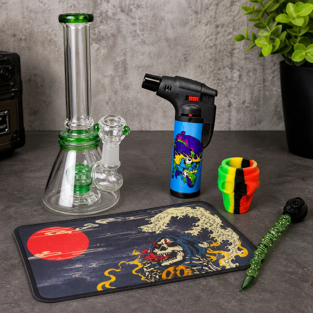Escena generada del kit Skull con bong transparente con detalles verdes, soplete, recipiente multicolor, utensilio y alfombrilla de calavera.