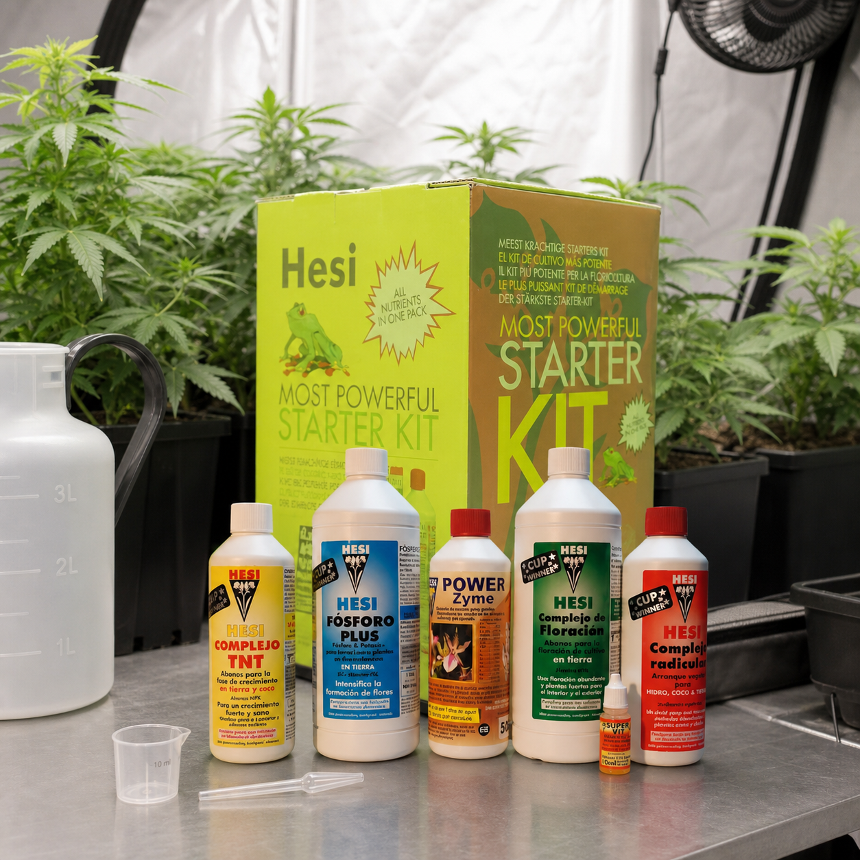 Kit Hesi Starterbox Suelo con caja, varios botes y utensilios de dosificación sobre una mesa, delante de plantas en macetas. Kit Hesi Starterbox Suelo con caja, varios botes y utensilios de dosificación sobre una mesa, delante de plantas en macetas.