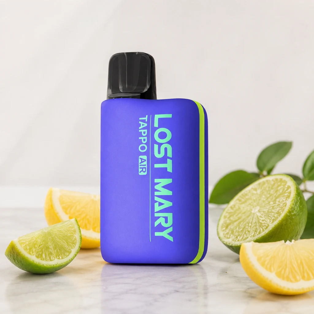 Vapeador morado con borde verde y boquilla negra, rotulado Lost Mary Tappo Air, rodeado de trozos de limón y lima.