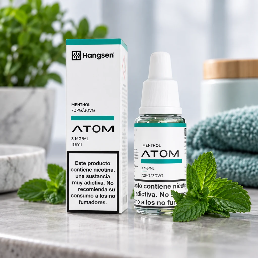 Escena generada de un frasco y caja Hangsen Atom Menthol, con etiqueta de 3 mg/ml y 10 ml, junto a hojas de menta y toallas.
