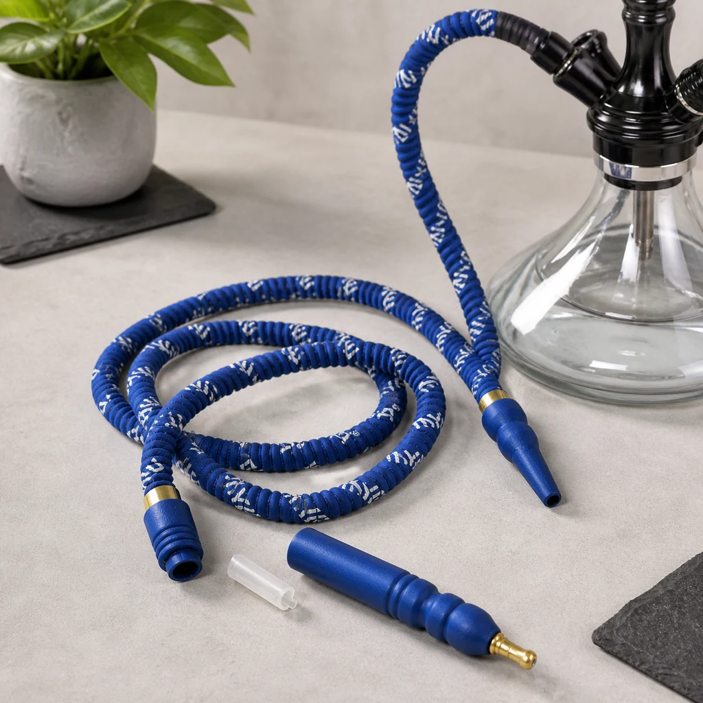 Manguera azul con detalles blancos enrollada junto a una cachimba de base transparente y una boquilla azul separada con conector dorado. Manguera azul con detalles blancos enrollada junto a una cachimba de base transparente y una boquilla azul separada con conector dorado.