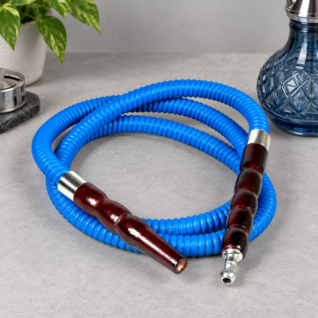 Manguera azul corrugada para cachimba, enrollada sobre una mesa gris, con extremos de color granate y conexiones plateadas. Manguera azul corrugada para cachimba, enrollada sobre una mesa gris, con extremos de color granate y conexiones plateadas.