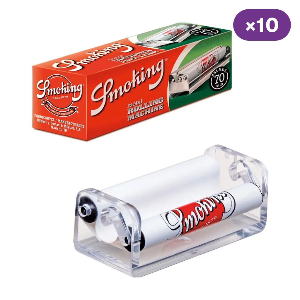 Máquina de liar Smoking con laterales transparentes y rodillos blancos, junto a su caja roja y verde y un distintivo de diez unidades.