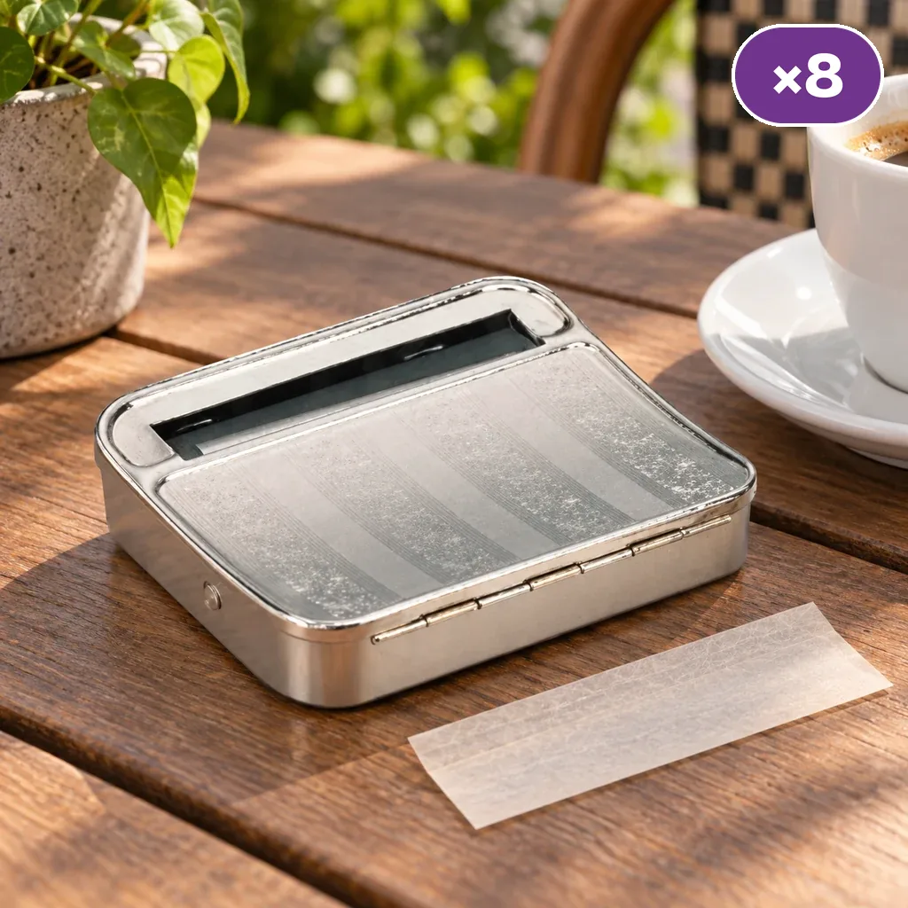 Máquina de liar metálica abierta sobre una mesa de madera, con una hoja de papel delante y un distintivo «×8».