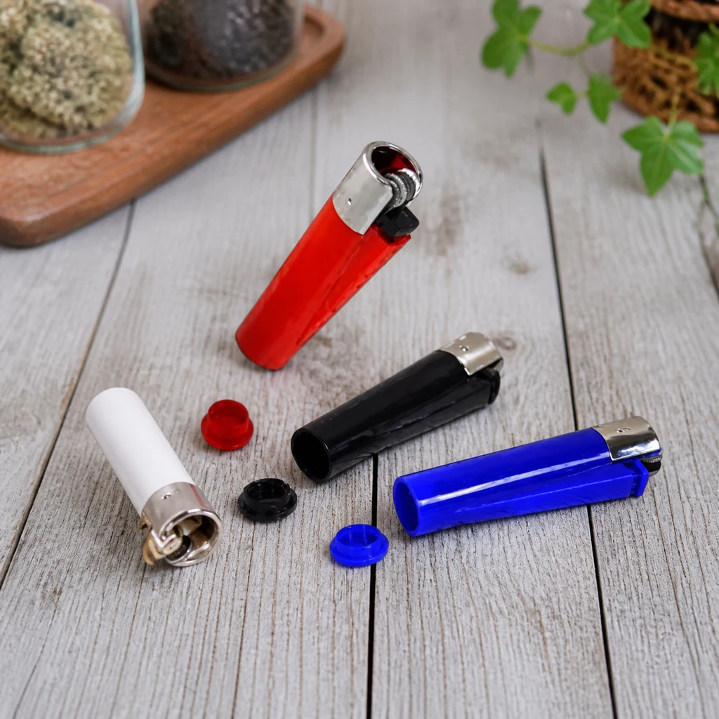 Mecheros rojo, blanco, negro y azul sobre una mesa de madera, con compartimentos abiertos y tres tapas retiradas.