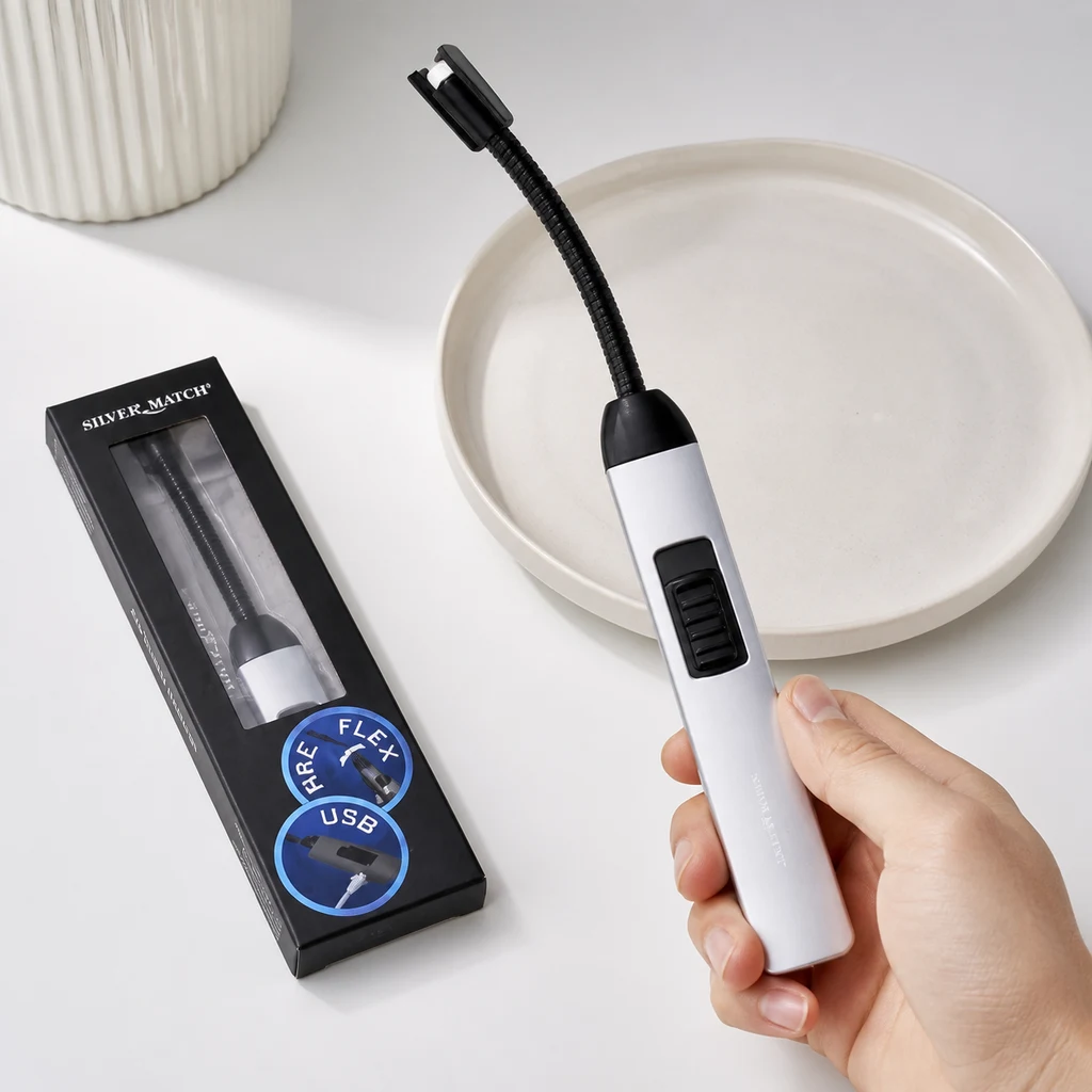 Una mano sostiene un encendedor Silver Match blanco con cuello negro flexible, junto a su caja con las indicaciones FLEX y USB.