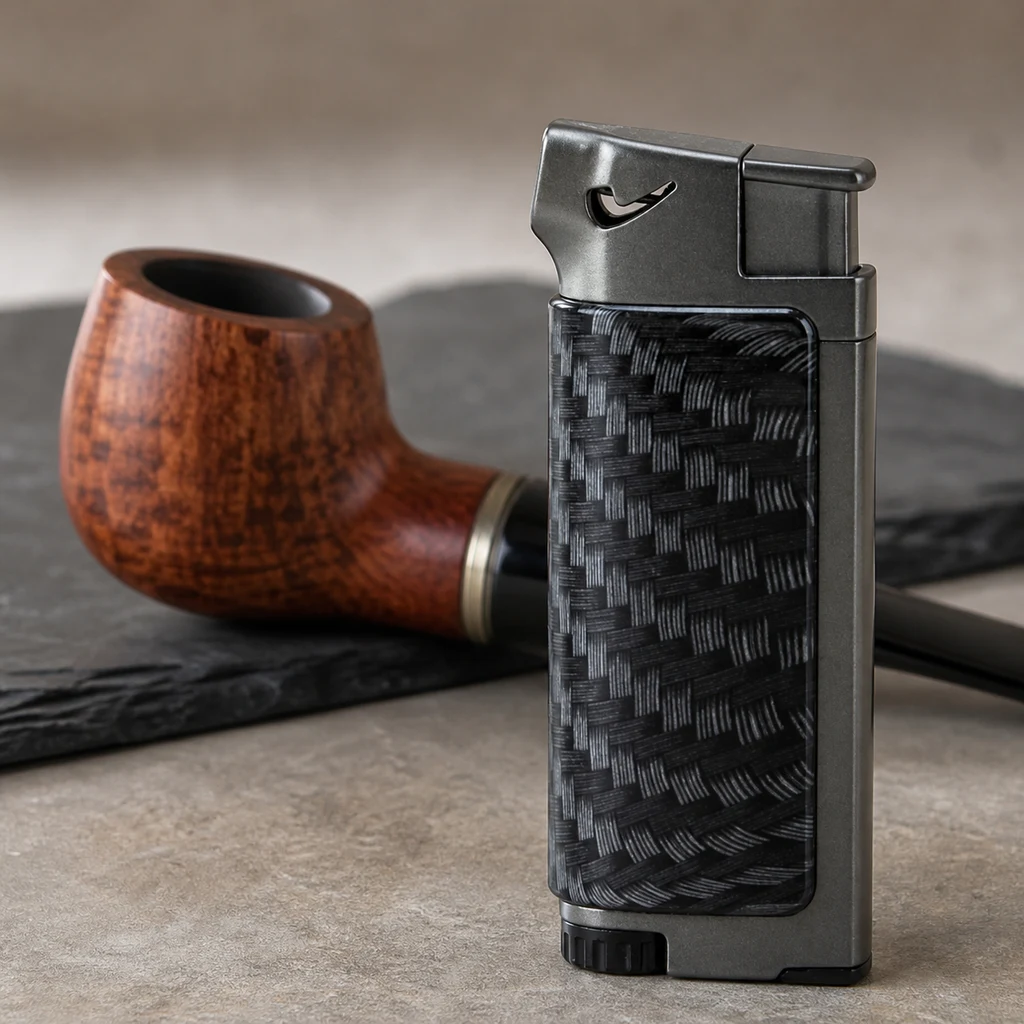 Encendedor Jean Claude Dundee gris con panel negro de trama entrecruzada, en primer plano junto a una pipa de madera.