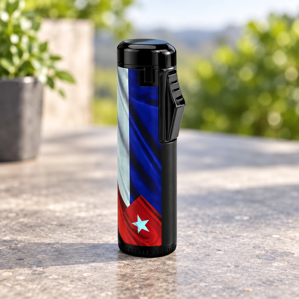 Mechero Cool Cuba negro con diseño de la bandera cubana y pulsador lateral, de pie sobre una mesa exterior.