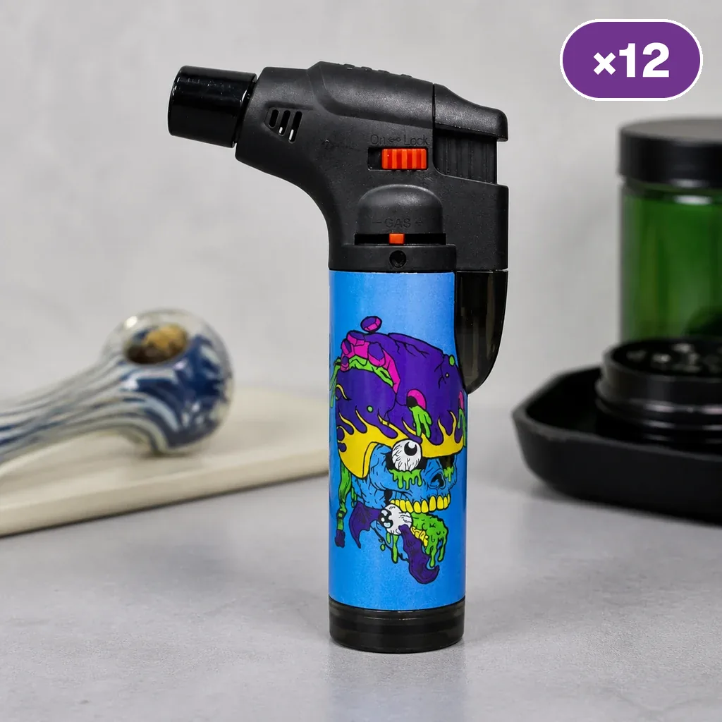 Encendedor turbo Prof Surf Crazy Skulls con cabezal negro, mandos naranjas y cuerpo azul decorado con una calavera multicolor.