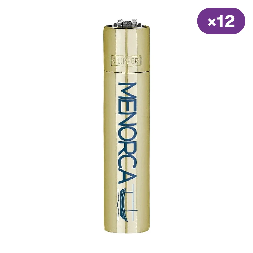 Encendedor Clipper de acabado dorado con la palabra Menorca y el dibujo azul de una embarcación, sobre fondo blanco.