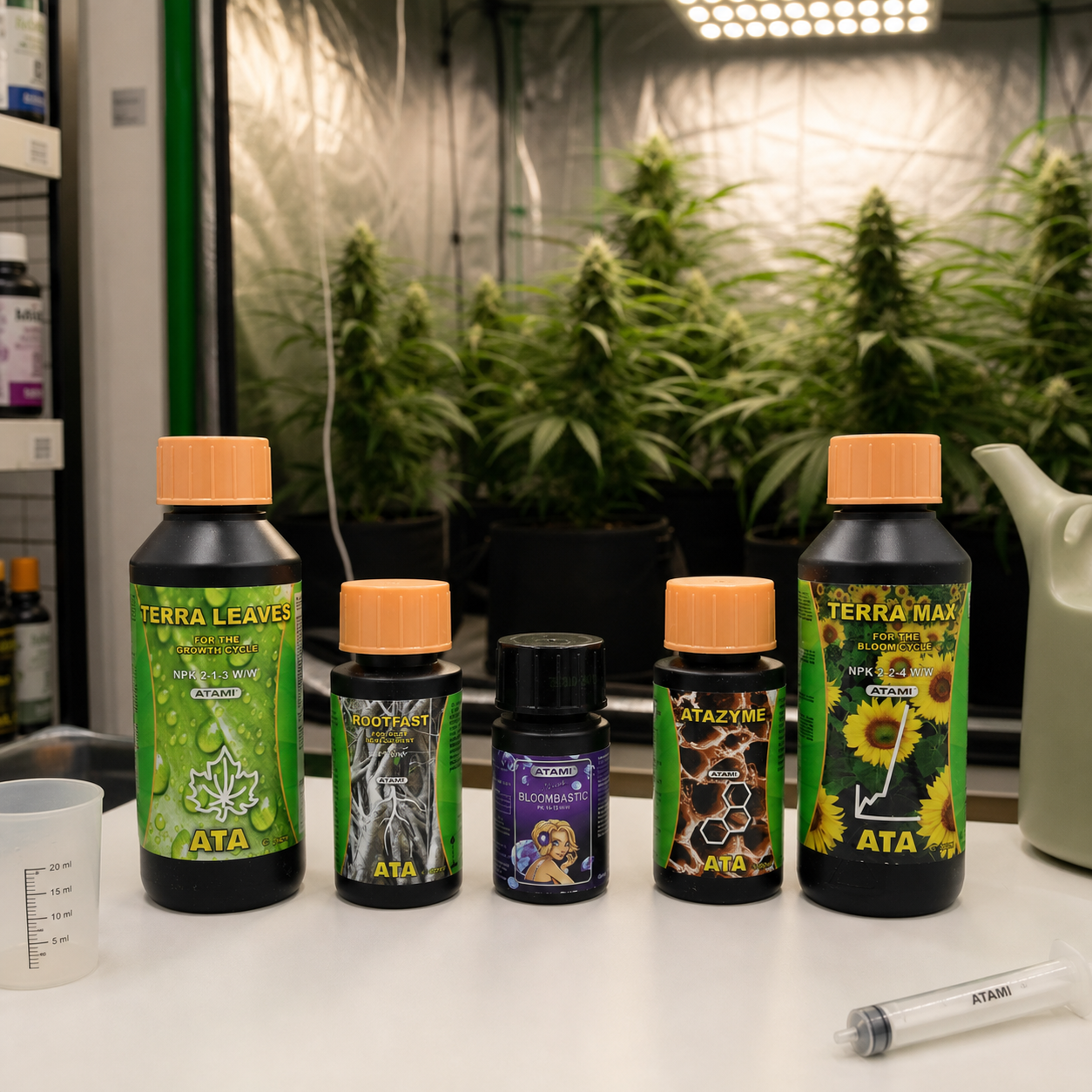 Botes del Micro Kit ATA Terra sobre una mesa con vaso medidor y jeringa, frente a plantas de cannabis bajo una lámpara de cultivo. Botes del Micro Kit ATA Terra sobre una mesa con vaso medidor y jeringa, frente a plantas de cannabis bajo una lámpara de cultivo.