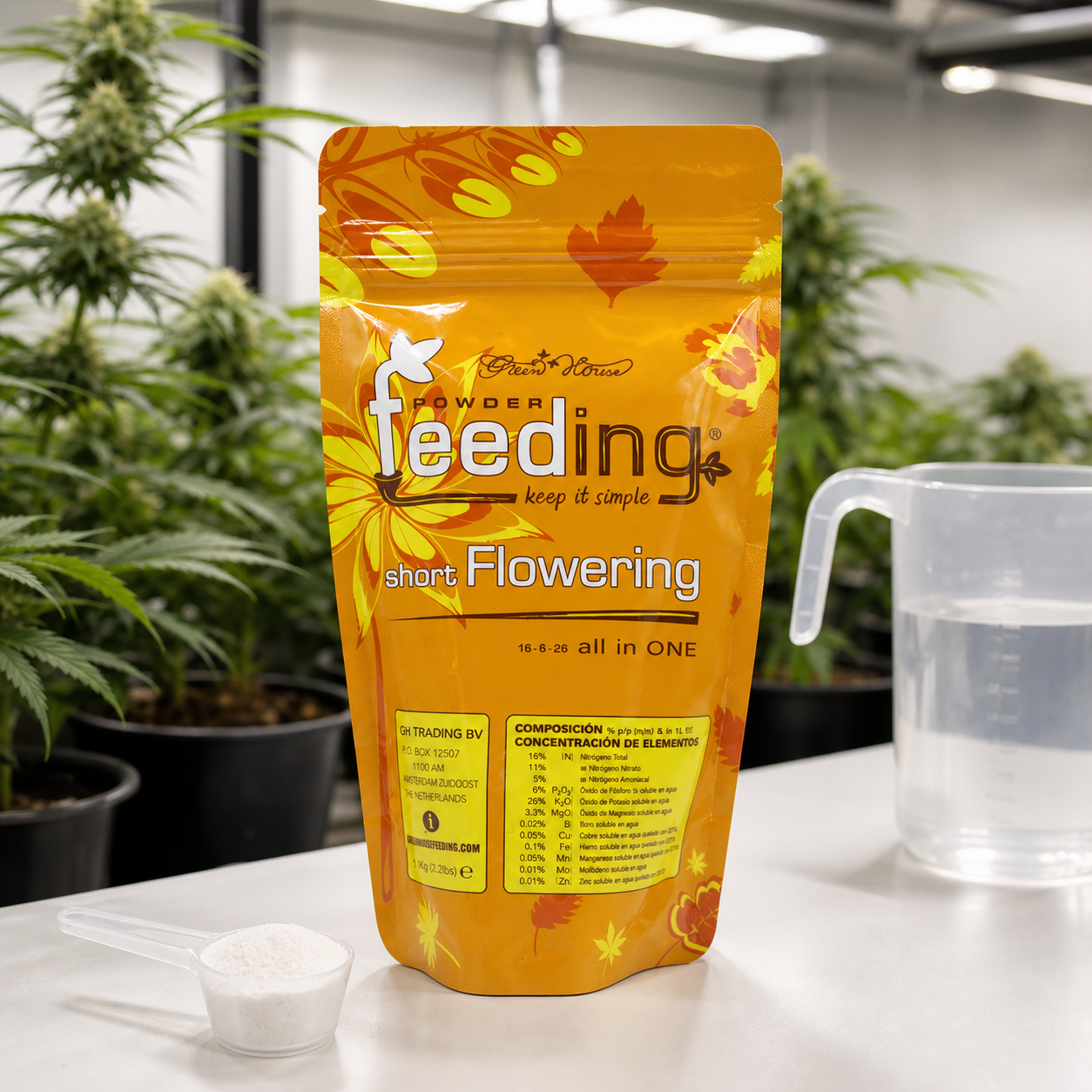 Bolsa naranja de Powder Feeding Short Flowering junto a una cuchara con polvo blanco y una jarra con agua, con plantas al fondo.