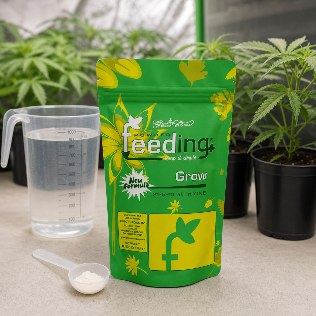 Bolsa verde de fertilizante Feeding Grow junto a una jarra con agua y una cuchara con polvo blanco, con plantas al fondo.