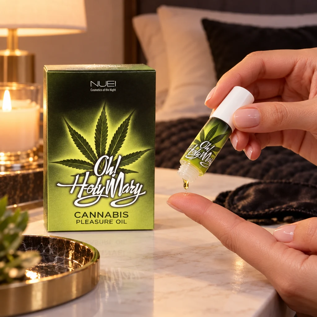 Una mano inclina un frasco de Oh! Holy Mary sobre un dedo, con una gota en la abertura y su caja verde junto a una vela. Una mano inclina un frasco de Oh! Holy Mary sobre un dedo, con una gota en la abertura y su caja verde junto a una vela.