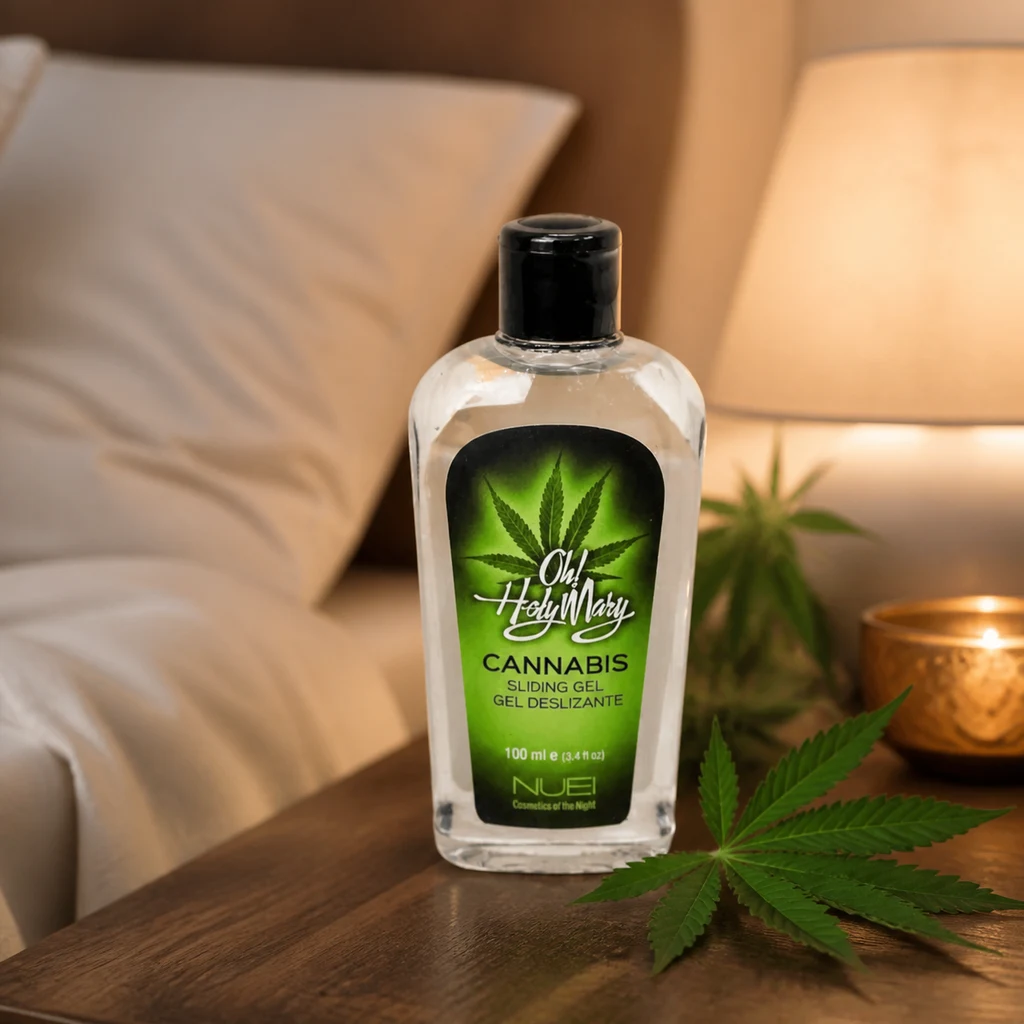 Frasco de gel Oh! Holy Mary con etiqueta verde sobre una mesita junto a una cama, una lámpara, una vela y una hoja de cannabis.