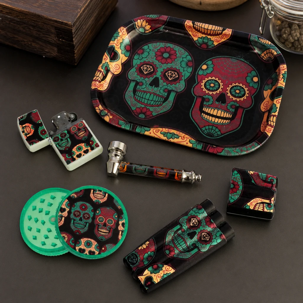 Accesorios con calaveras florales sobre una mesa oscura: bandeja, grinder abierto, pipa, encendedor y piezas rectangulares.
