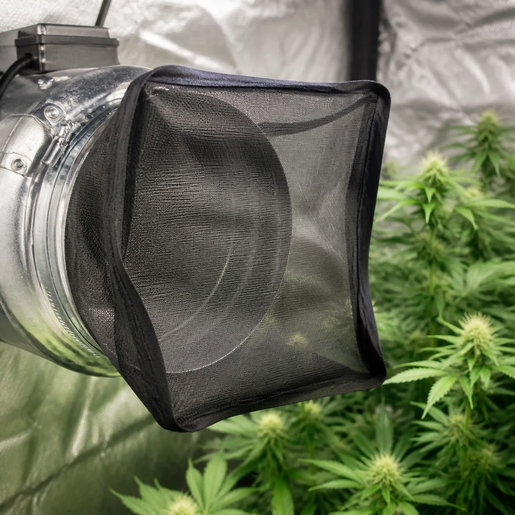Escena generada de una malla negra RAM Bug Barrier colocada sobre la boca de un extractor metálico junto a plantas.