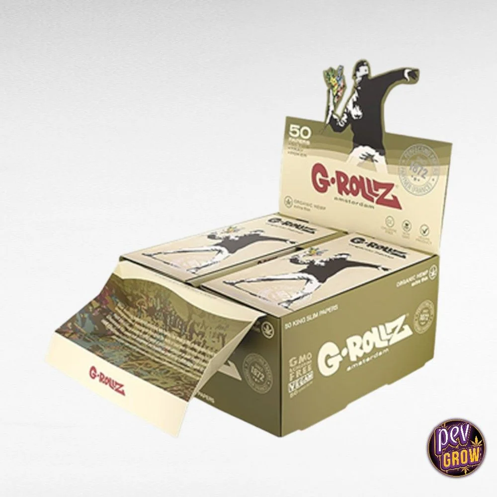 Expositor abierto de papel de liar G-Rollz Banksy con estuches beige y verde oliva y una figura con el brazo levantado.