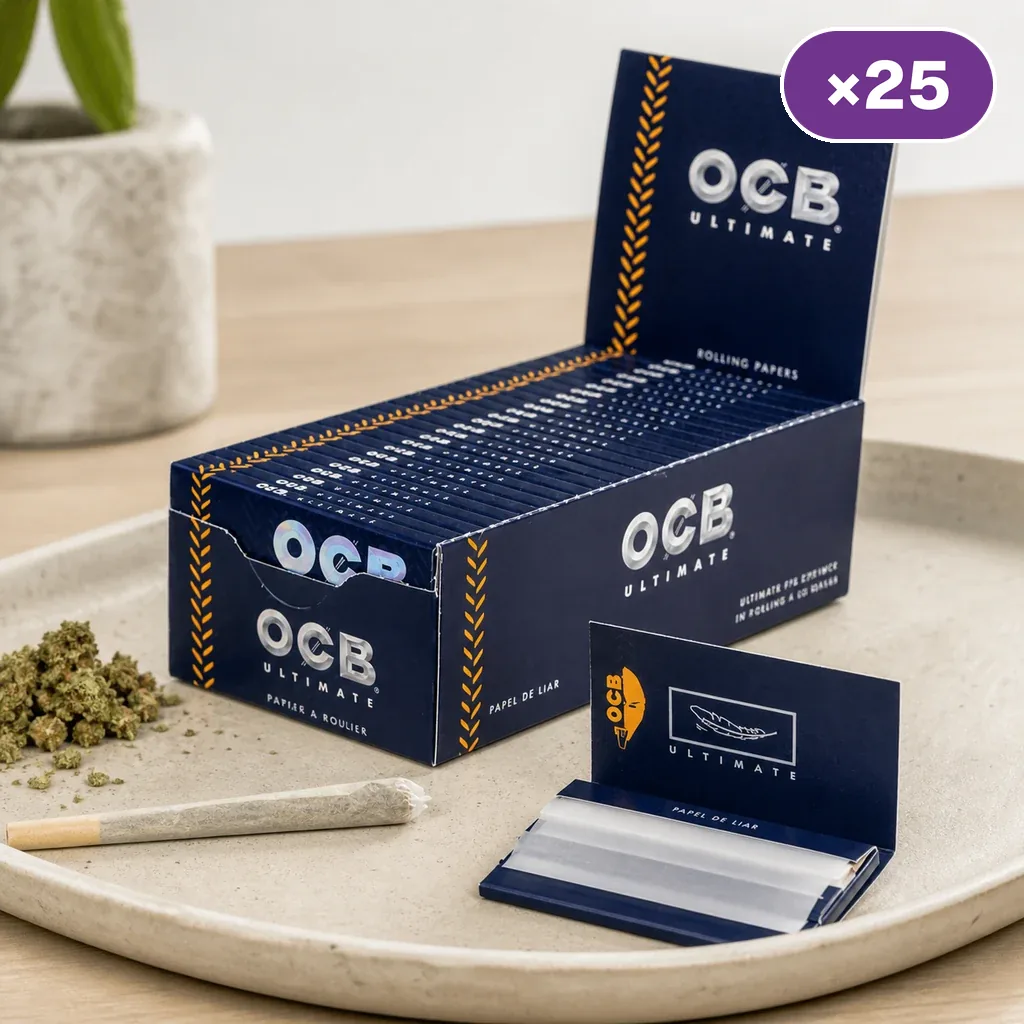 Caja expositora de papel OCB Ultimate con varios libritos, uno abierto sobre una bandeja junto a un cigarrillo liado; distintivo de 25 unidades.