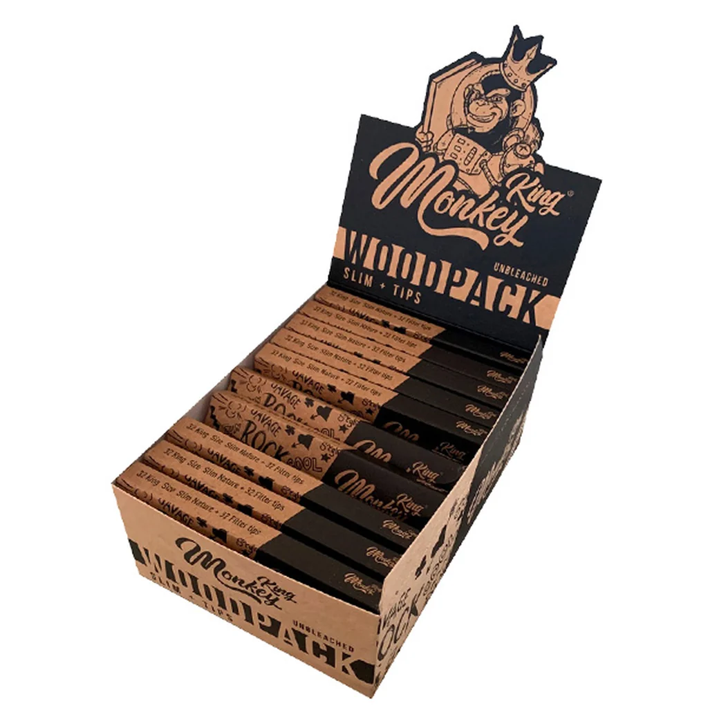 Expositor Monkey King Woodpack con varios librillos marrones y negros de papel de liar y filtros, y un mono coronado en la cabecera.