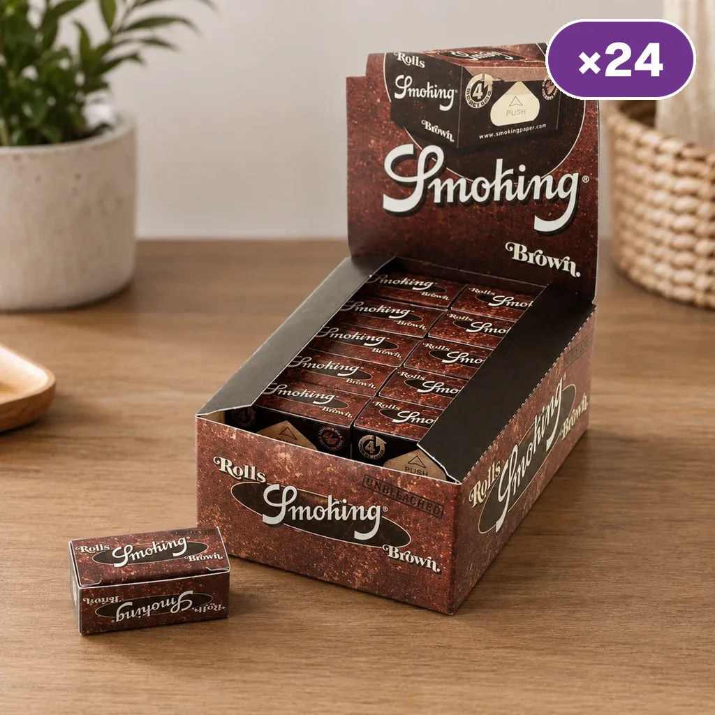Caja expositora abierta de Smoking Rolls Brown con varias unidades y una cajita delante, sobre una mesa de madera; distintivo de 24 unidades.