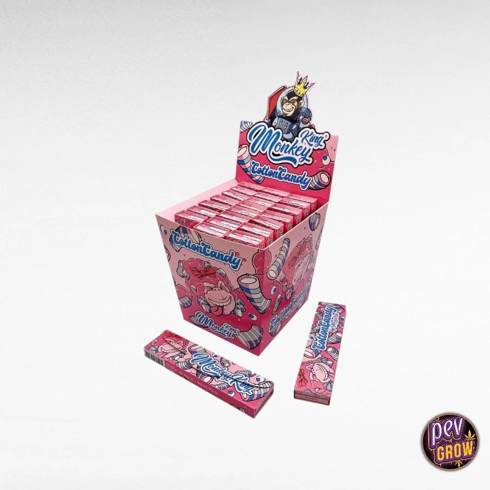 Expositor rosa de papeles Monkey King Cotton Candy con estuches alineados y dos unidades delante, decorado con monos y dulces.