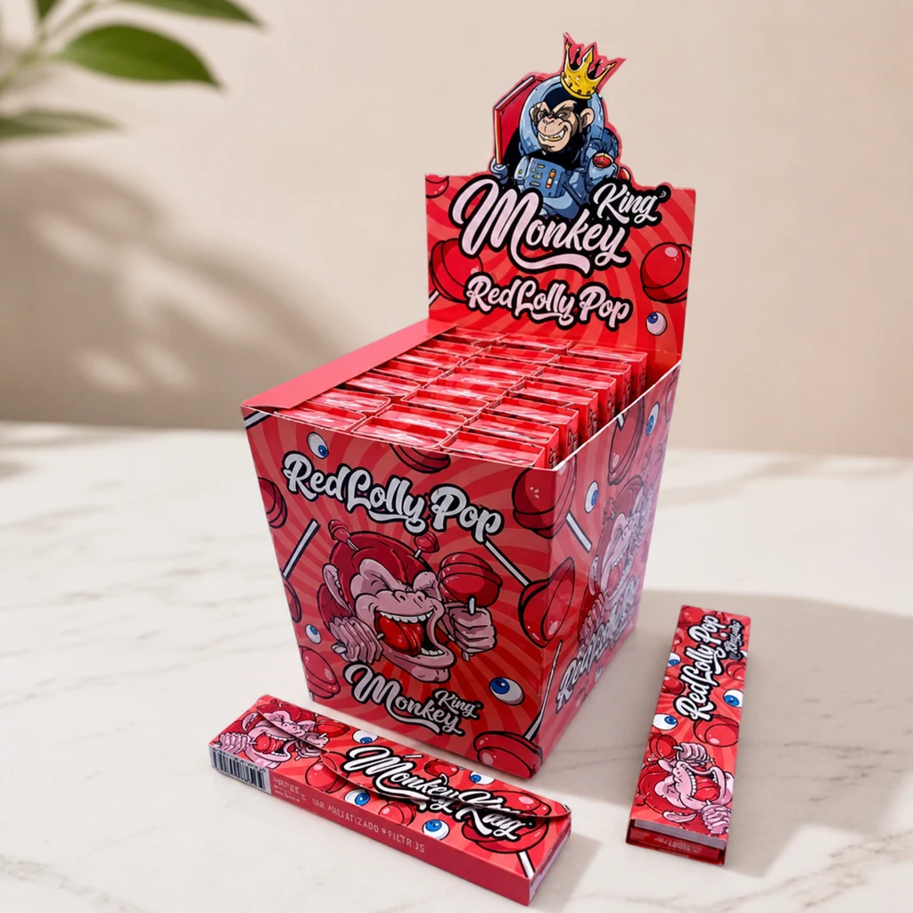 Expositor rojo de papel de liar Monkey King Red Lollypop, con dibujos de monos y piruletas y varios libritos sobre una mesa.