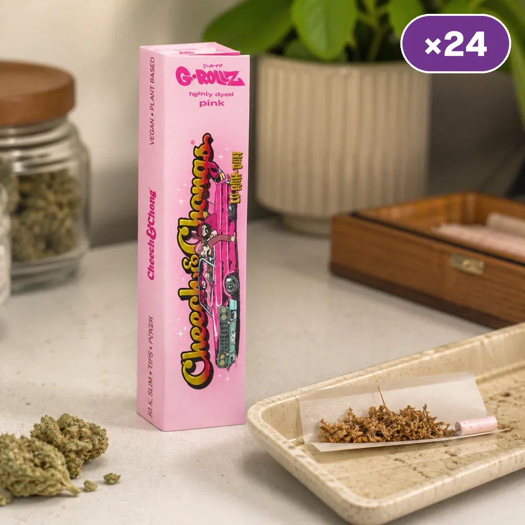 Caja rosa G-Rollz Cheech & Chong junto a una bandeja con papel abierto, mezcla vegetal y filtro rosa; distintivo de 24 unidades.