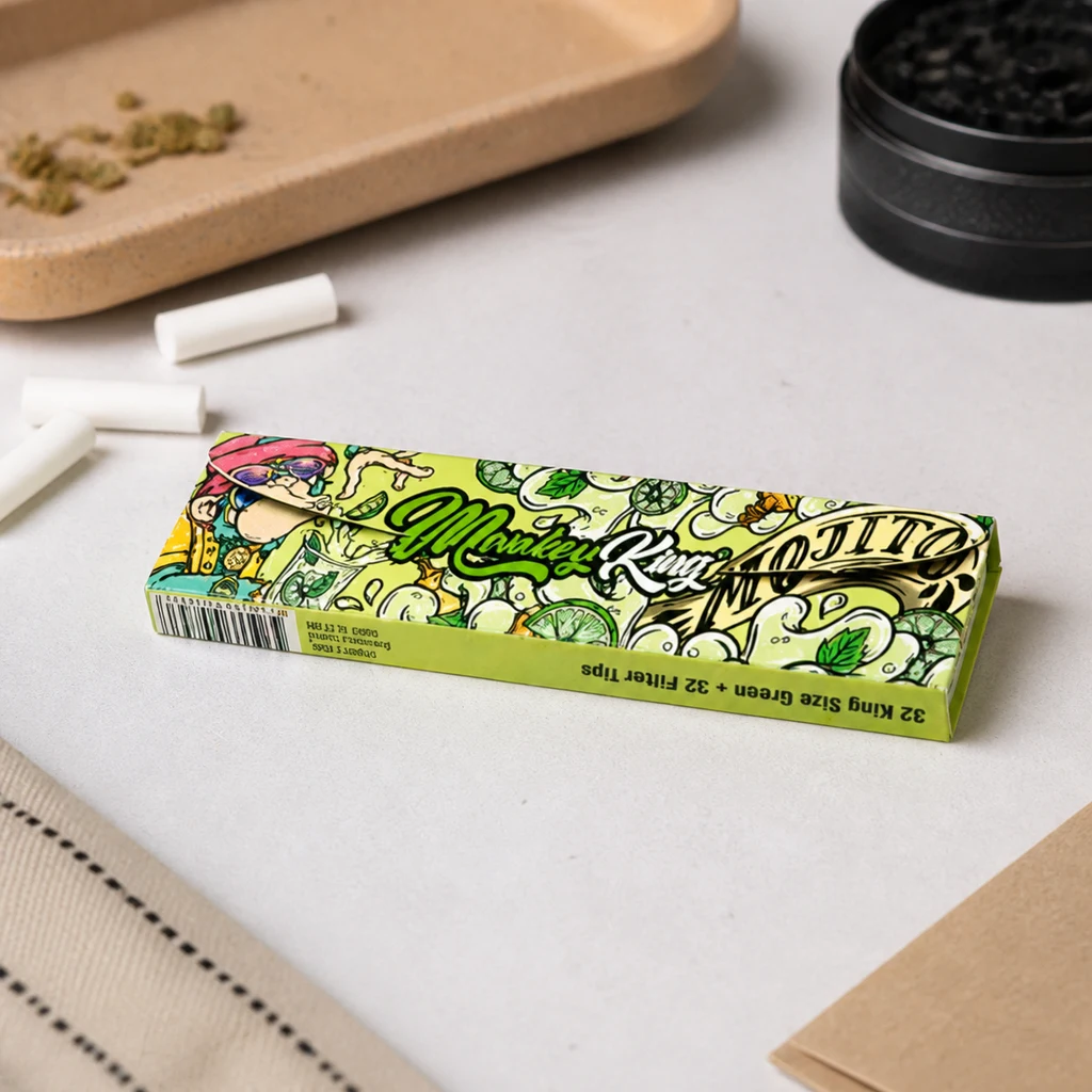 Estuche verde Monkey King Mojito de papel y filtros sobre una mesa, con ilustraciones de limas y menta y filtros sueltos alrededor.