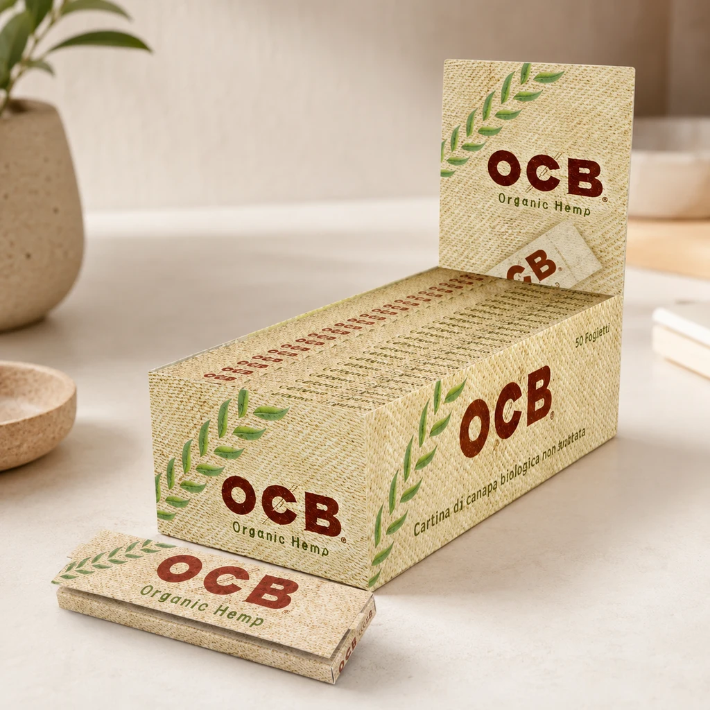 Caja expositora y librillo OCB Organic Hemp de tono beige con motivos de hojas verdes, sobre una encimera clara.